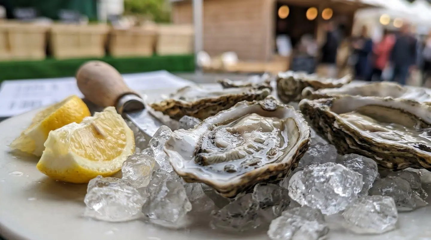 Gros plan sur des huîtres fraîches disposées sur un lit de glace pilée avec quartiers de citron, texture brillante des coquilles visible