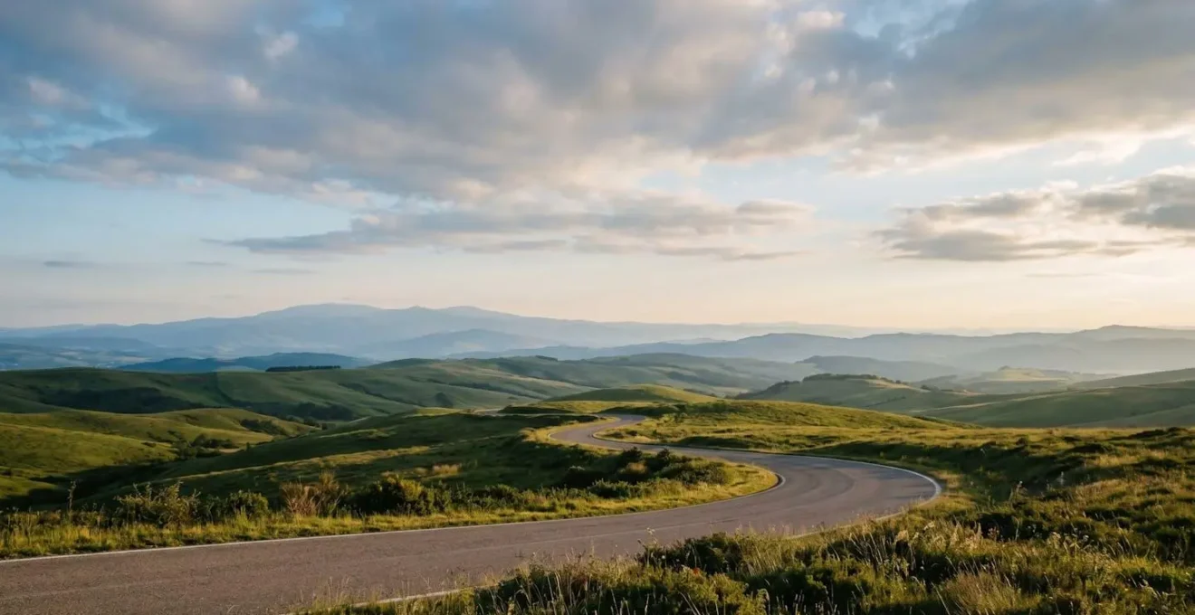 Paysage européen panoramique avec route serpentant à travers des collines verdoyantes